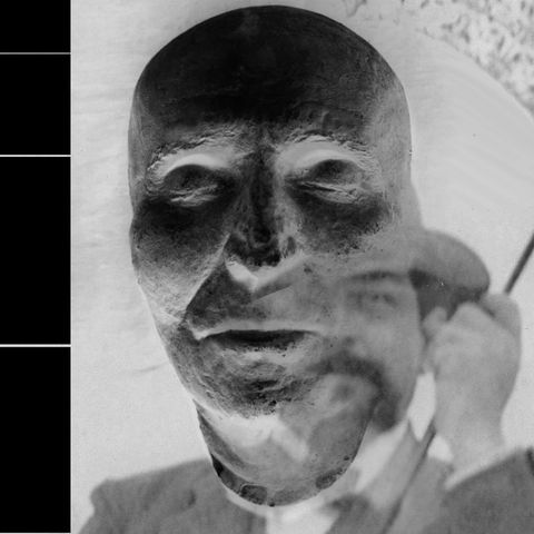 An amalgam of the death mask of Joseph Haydn and a photograph of Claude Debussy holding an umbrella emerging out of the lower left cheek of Haydn, monochromatic.