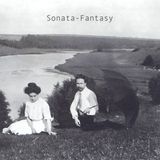 A monochromatic photograph of Alexander Scriabin and Tatiana Schloezer, seated on the grass with the Oka River in the background. Scriabin is holding an open umbrella in one hand.